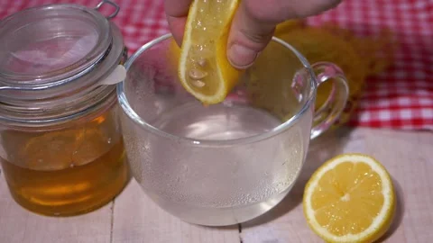 Squeezing a lemon for homemade cold and flu remedy Stock Footage 164746875