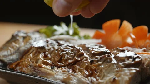 Squeezing lemon juice on grilled Mackerel fish in slow motion Stock Footage 152980283