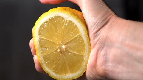 Squeezing lemon juice from half a lemon-4 Stock Footage 125500096