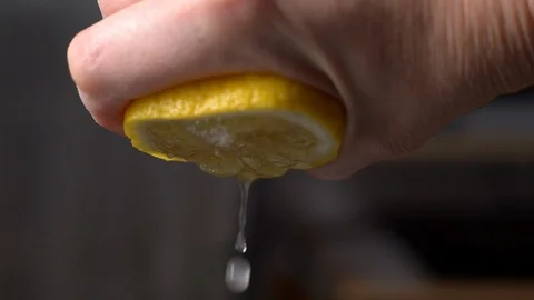 Squeezing lemon juice from half a lemon-3 Stock Footage 125500114