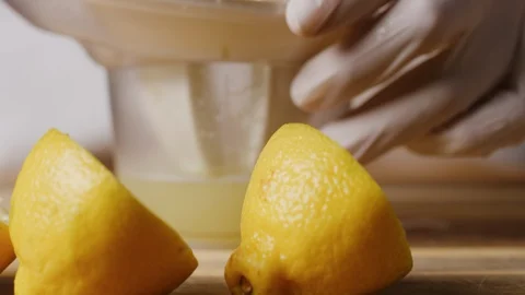 Squeezing lemon on juicer macro shot Stock Footage 128487153