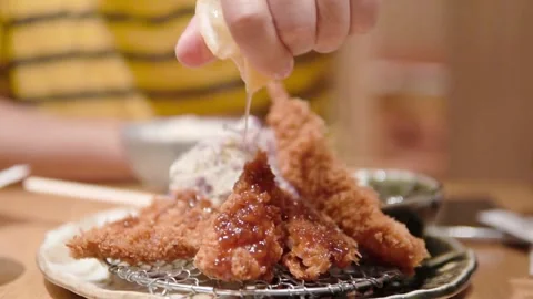 Squeezing lemon over deep fried calamari seafood. hand squeezing lemon onto Stock-Footage 336588804