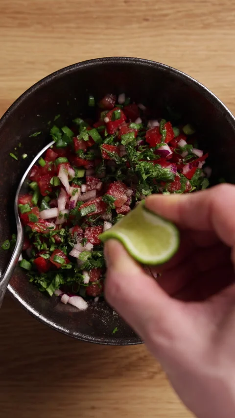 Squeezing Lime Juice over Fresh Tomato Salsa Vertical Top View Vidéo 336575343