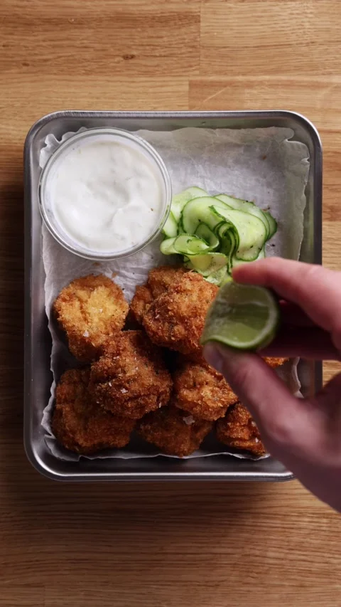 Squeezing Lime Wedge Over Shrimp Cakes Top View 스톡 동영상 331878678