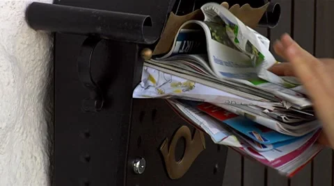 Squeezing mail into postbox Stock Footage