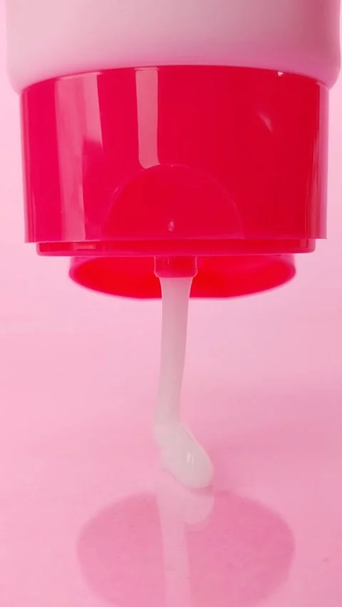 Squeezing or dispensing white beauty serum from a bright pink cosmetic bott.. Vídeos de archivo 330749476