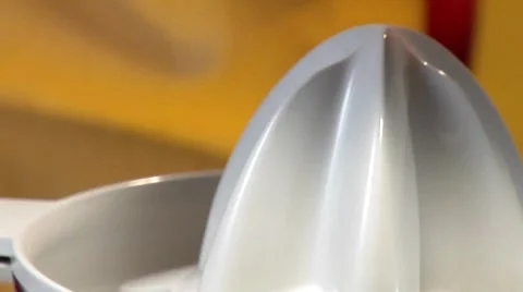 Squeezing an orange with an electric citrus squeezer (close-up) Stock Footage 8573806