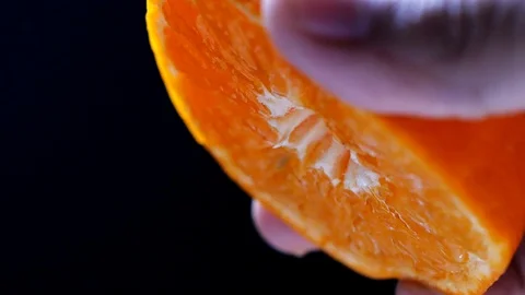 Squeezing orange fruit in slow motion on black background Stock-Footage 113596427