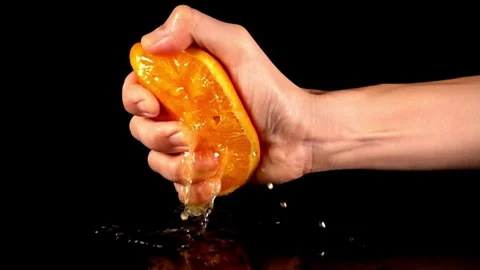 Squeezing an orange half on black background. Citrus fruit source of vitamins Stock-Footage 336588891