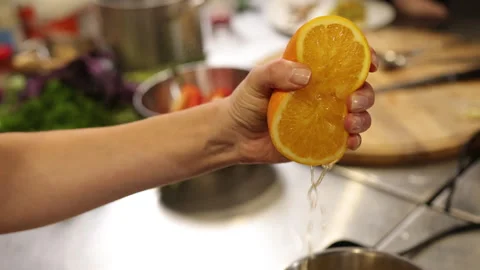 Squeezing orange, hand squeezing, juice dripping Stock Footage 297379478