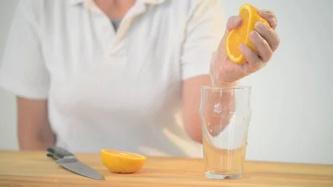 Squeezing Orange Juice into a Glass Stock Footage 80065815