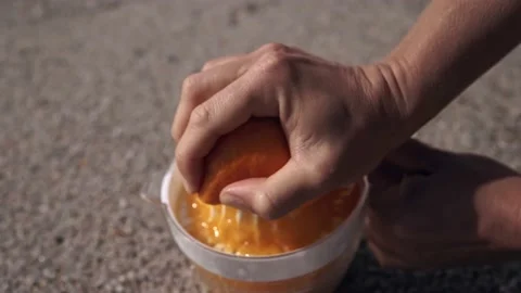 Squeezing orange juice on the sand. Top view Video stock 209577866