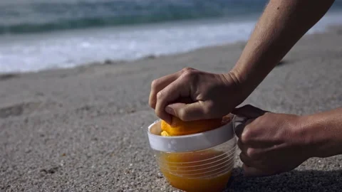 Squeezing orange juice on the surf of the ocean Stock Footage 221805200