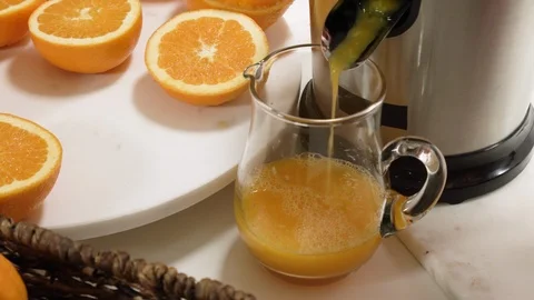 Squeezing orange juice using an electric juicer. Stock Footage 125538720