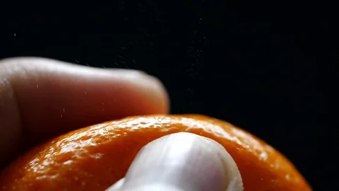 Squeezing orange peel in slow motion on black background. Health food Stock Footage 113596847