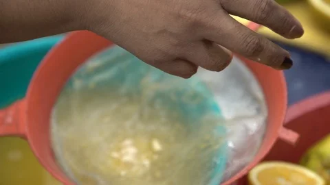 Squeezing oranges into strainer Stock Footage 108548357