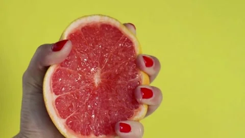 Squeezing out the fresh orange. A footage of a person's hand squeezing orange Vídeo Stock 336588883