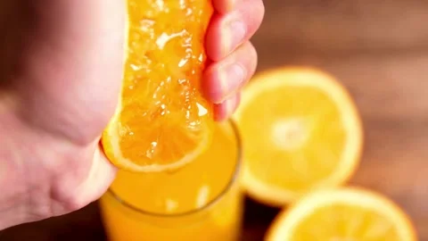 Squeezing out the fresh orange. A picture of a person's hand squeezing orange Stock-Footage 336588887
