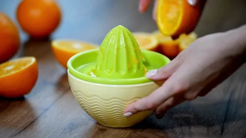 Squeezing out the fresh orange. A picture of a person's hand squeezing orange Stock-Footage 336588927