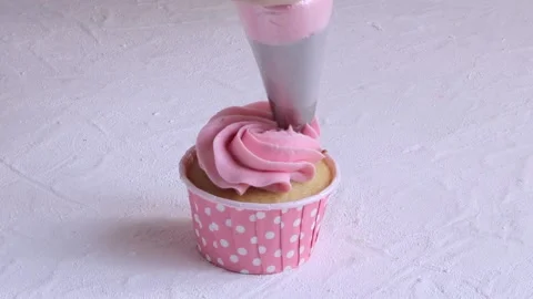 Squeezing pink cream on birthday cupcake. Close up Stock Footage 150319086