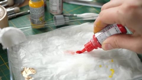 Squeezing red paint onto a wet palette, painting minis, miniatures for rpg game Stock Footage 260824098
