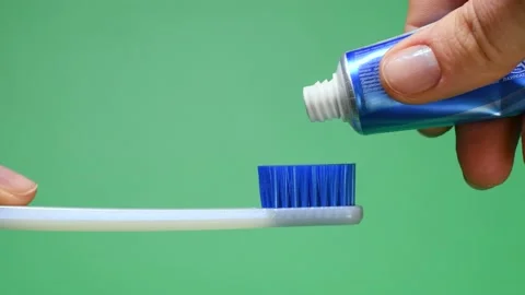 Squeezing tooth paste on toothbrush Stock Footage 136257739