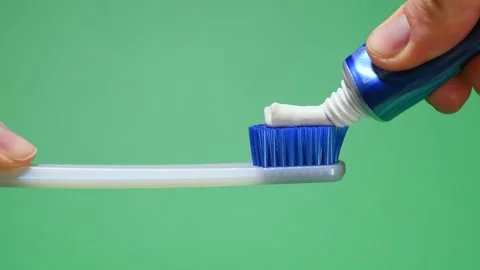 Squeezing tooth paste on toothbrush Stock Footage 136423315