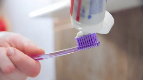 Squeezing tooth paste on toothbrush Stock-Footage 143623983
