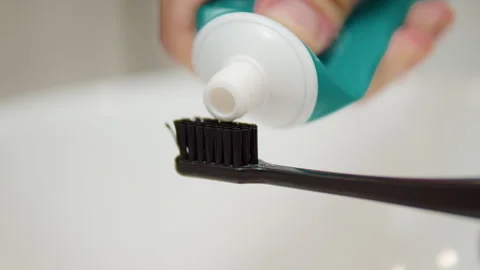 Squeezing toothpaste onto black toothbrush Stock Footage 311693040