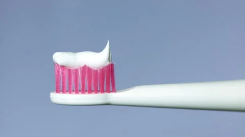 Squeezing toothpaste onto a toothbrush for daily dental hygiene routine Stock Footage 340264173