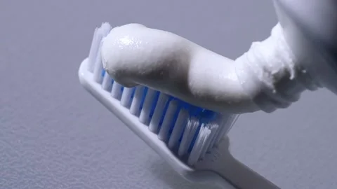 Squeezing toothpaste onto toothbrush Stock Footage 213636061