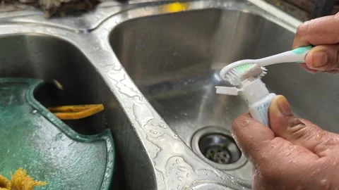 Squeezing Toothpaste onto Toothbrush Over Sink Stock Footage 325416451