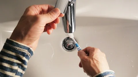 Squeezing toothpaste from a tube on a toothbrush Stock Footage 114181623