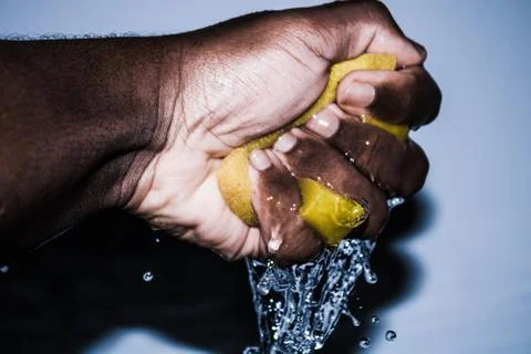 Squeezing a Yellow Sponge Background Stock Photos