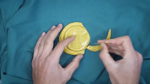 Squid Game. Hands scrape sugar candy cookie with needle and break it Stock Footage 163894535