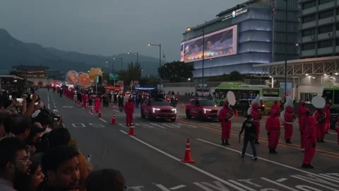 Squid Game-Inspired Parade with Drummers and Floats During Night Festival in Stock Footage 312684333
