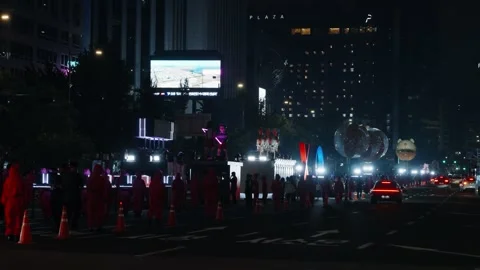Squid Game Parade Night Street Scene with Pink Guards and Floats in Seoul Stock Footage 312772533