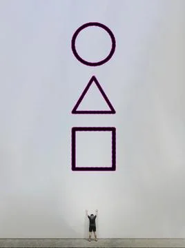 Squid game player standing facing a white wall giant logo Stock Photos