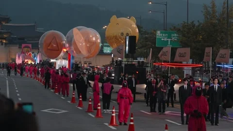Squid Game themed parade with balloons and costumed participants in Seoul Stock Footage 312683795