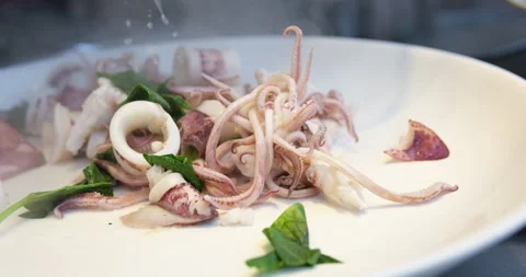Squid grilling on hot pan. Chef cooking delicious seafood squid in restaurant Stock Footage 277303378