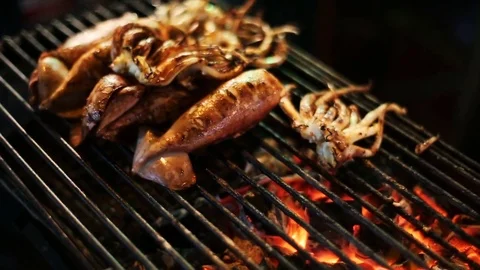 Squid grilling over open flames Stock Footage 75336835