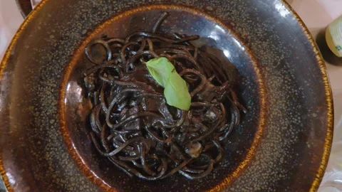 Squid Ink Pasta Spinning on a Plate Stock Footage 343339411