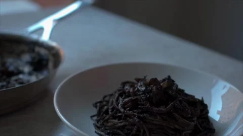 Squid ink spaghetti (spaghetti al nero di seppia)  served on a white plate Stock Footage 249252051