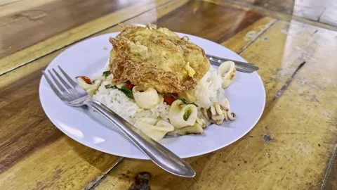 Squid Pad Krapao with crispy Fried egg Stock Footage 256243413