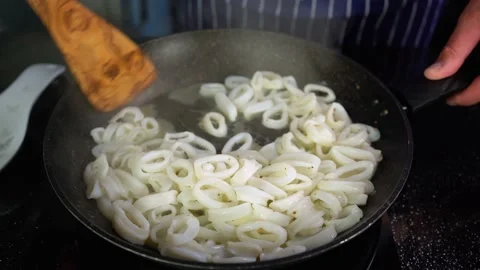 Squid rings are fried in a pan, the cook fries calamari rings, closeup, 4K Stock Footage 135189986
