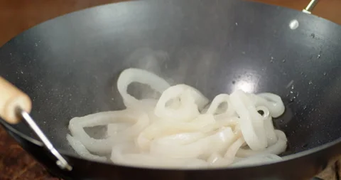 Squid rings are put in a frying pan. Stockbeeldmateriaal 144581251