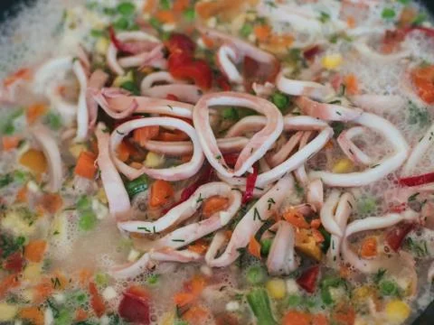 Squid with vegetables are cooked in a pan Stock Photos