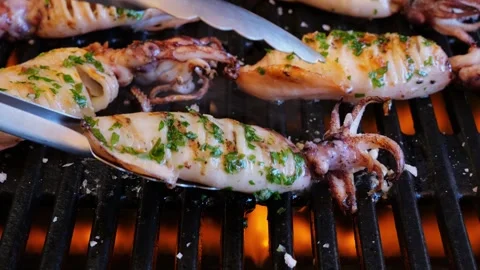 Squids on grill, turn over. Slow motion. Close up. Open flame Video stock 252762396
