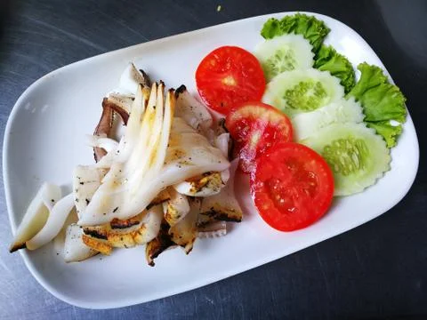 Squids grilled with tomatoes cucumbers Stock Photos