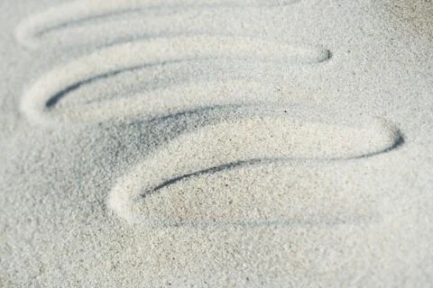 Squiggly pattern drawn in sand Foto stock